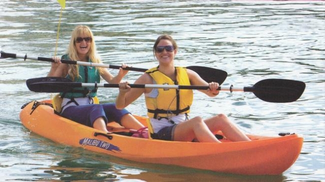 Dos mujeres jóvenes en los kayaks 